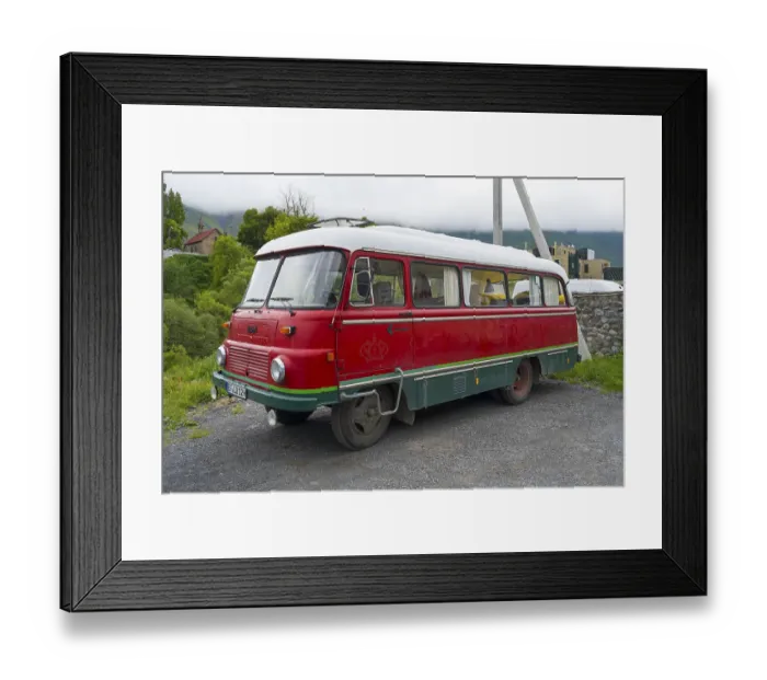 Framed Print : Red retro bus with green stripes on a road in a rural mountain landscape