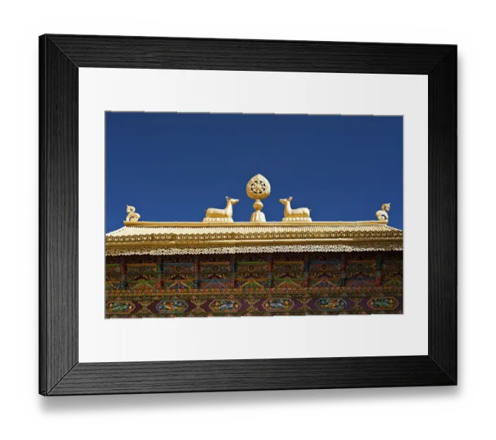 Framed Print : Buddhist symbols: Dharma-wheel and deer on decorated roof under blue sky at Thiksey Gompa