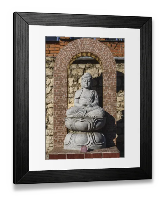 Framed Print : White stone statue of a Buddha on masonry background Framed Print : White stone statue of a Buddha on masonry background