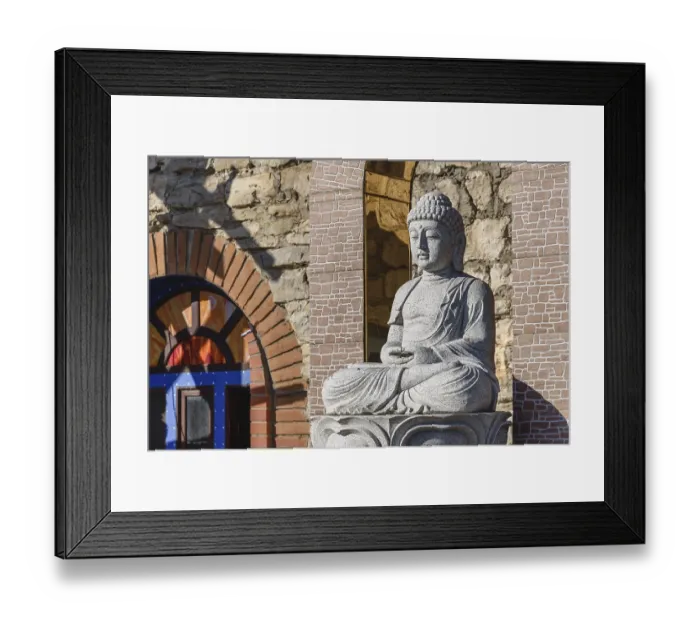 Framed Print : White stone statue of a Buddha on masonry background