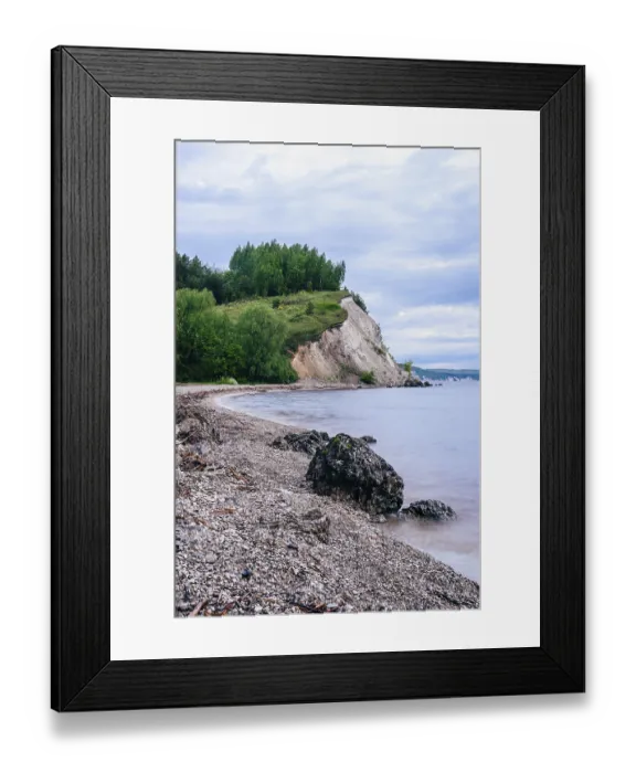 Framed Print : Stone on the riverbank and cliff with birch woodland on background