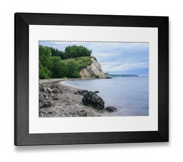 Framed Print : Stone on the riverbank and cliff with birch woodland on background