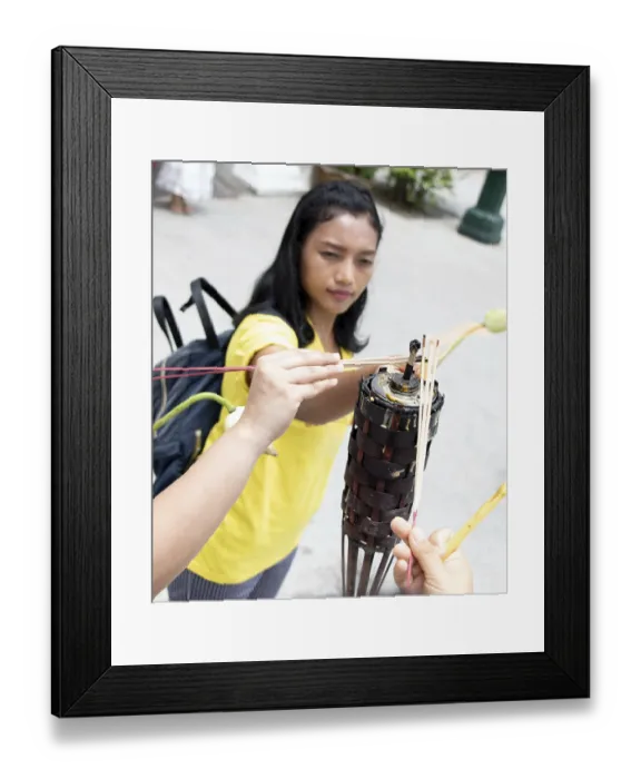 Framed Print : A young woman ignite stick in the Buddhist temple at Buddhist holiday Visakha (Vesak) Bucha day