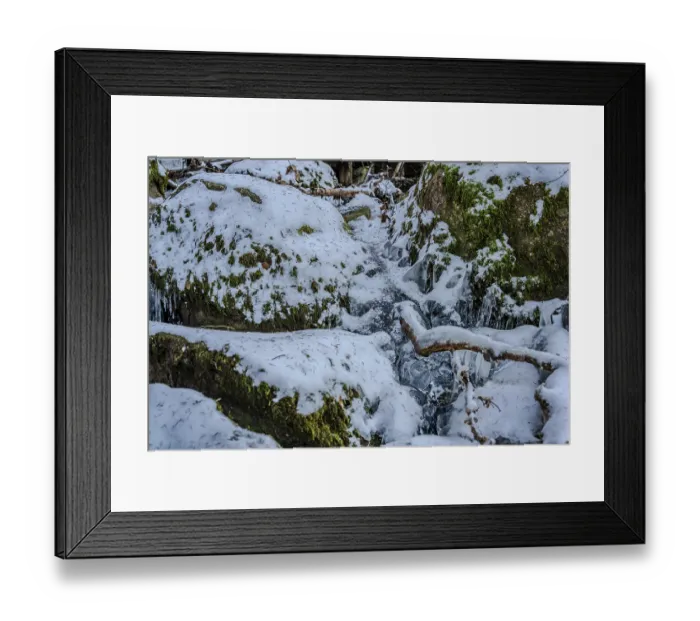 Framed Print : In a cold forest, water flows between rocks and is covered with snow and ice