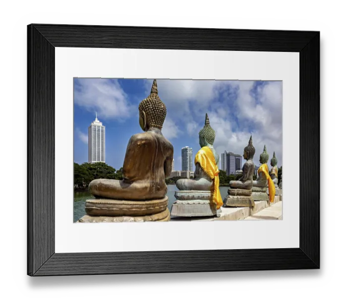 Framed Print : Back views of Buddha statues with yellow fabrics in front of a modern city
