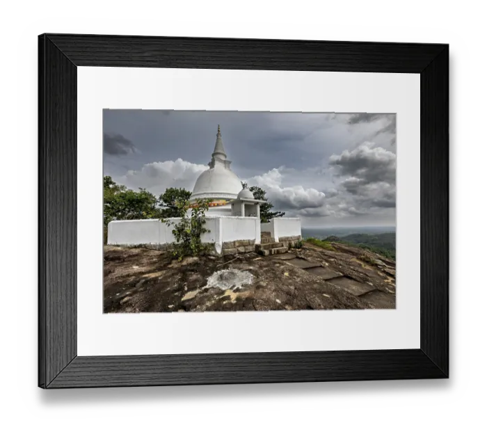 Framed Print : White stupa on rocky hill surrounded by cloudy skies and lush nature