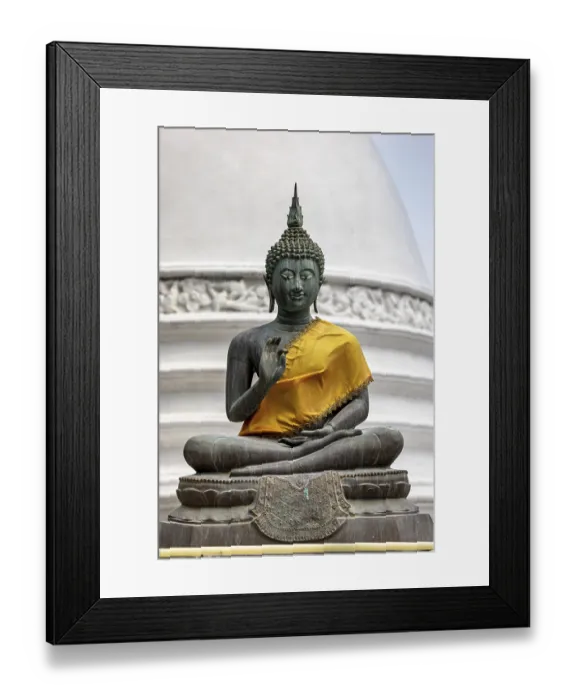 Framed Print : Bronze Buddha statue with yellow cloth in front of a white temple