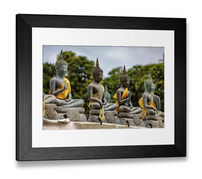 Framed Print : Several Buddha statues with yellow robes against a green backdrop Framed Print : Several Buddha statues with yellow robes against a green backdrop
