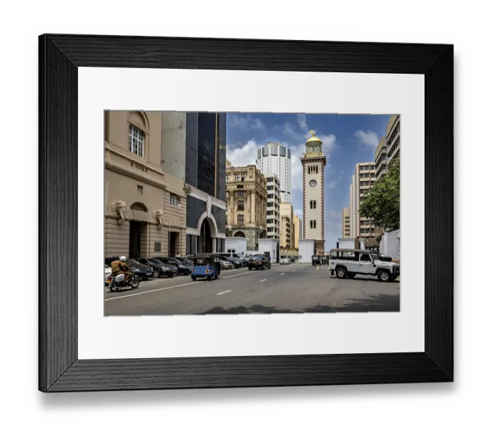 Framed Print : Urban street full of vehicles surrounded by modern and historic buildings under blue skies