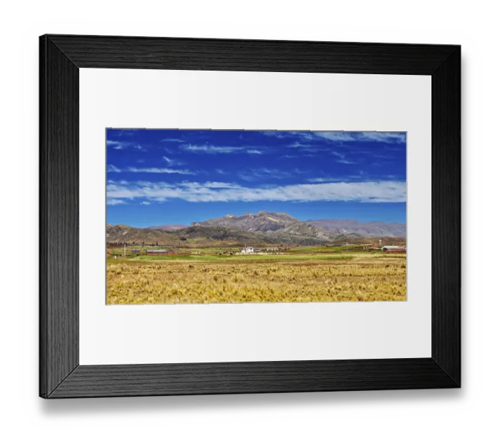 Framed Print : Wide fields in front of a mountain range under a cloudy sky