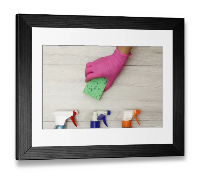 Framed Print : Hand in pink rubber glove holding sponge with bottles of detergent on wooden boards Framed Print : Hand in pink rubber glove holding sponge with bottles of detergent on wooden boards