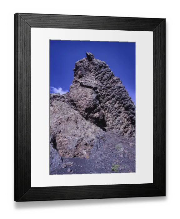 Framed Print : View of a high volcanic rock structure under a clear blue sky Framed Print : View of a high volcanic rock structure under a clear blue sky