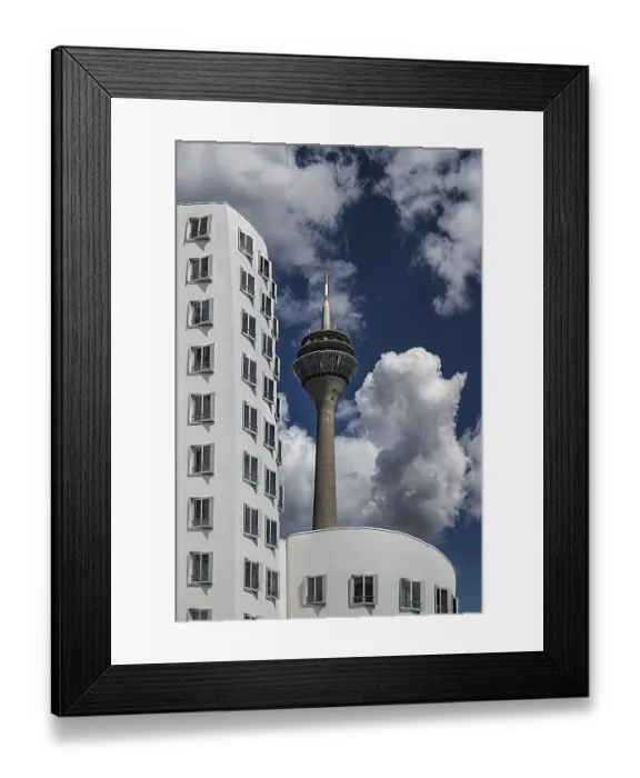 Framed Print : The Dusseldorf Rhine Tower rises behind the distinctive facade of one of the Gehry buildings Framed Print : The Dusseldorf Rhine Tower rises behind the distinctive facade of one of the Gehry buildings