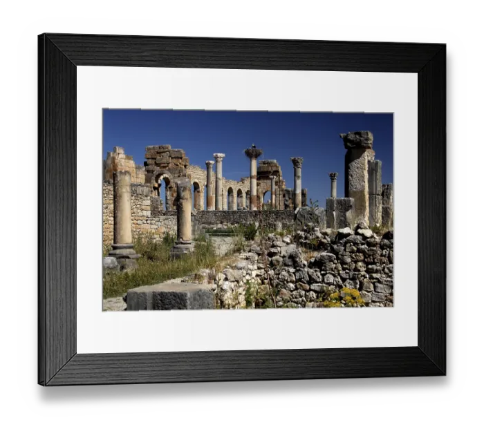 Framed Print : Detailed view of the basilica of Volubilis with well-preserved columns against a bright blue sky