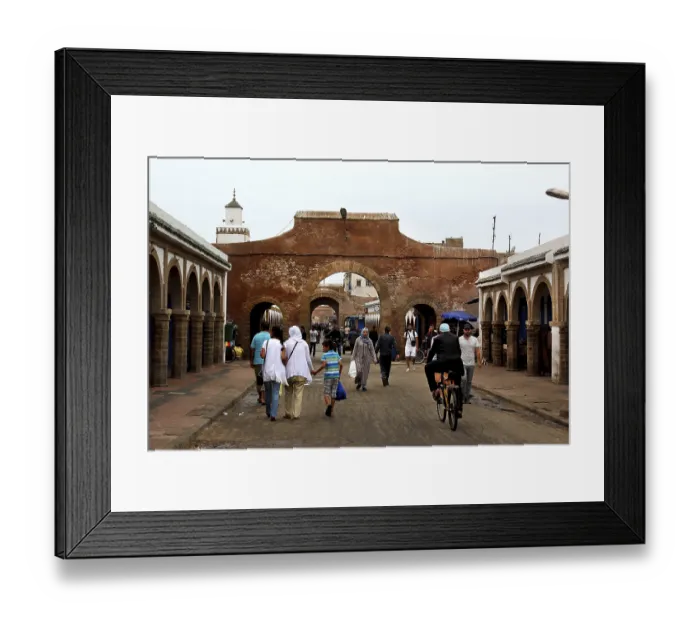 Framed Print : People walk through a historic stone gate in the souk of Essaouira