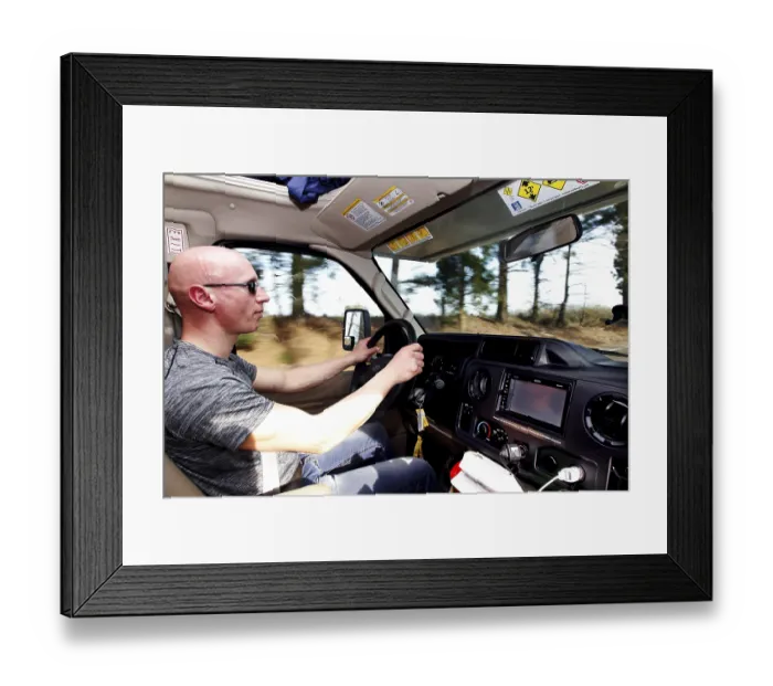 Framed Print : A man drives an RV on a tree-lined road Framed Print : A man drives an RV on a tree-lined road