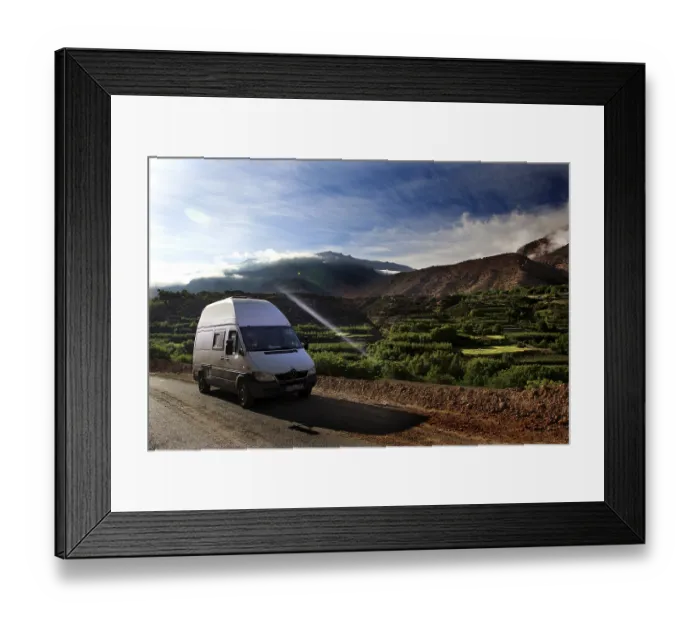 Framed Print : A van on a road with breathtaking views of the green fields of the mountains Framed Print : A van on a road with breathtaking views of the green fields of the mountains