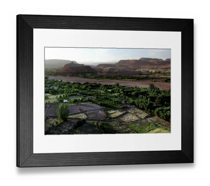 Framed Print : Extensive valley with green meadows and a river in the distance