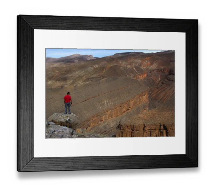 Framed Print : A person wearing a red jacket looks at the Dades Canyon with impressive rock formations Framed Print : A person wearing a red jacket looks at the Dades Canyon with impressive rock formations