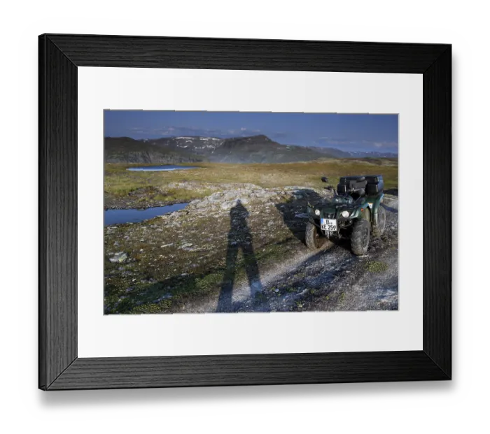Framed Print : ATV is standing on a dirt road next to a long shadow of people in the vast countryside Framed Print : ATV is standing on a dirt road next to a long shadow of people in the vast countryside