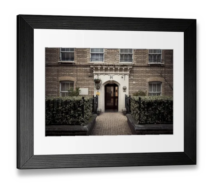 Framed Print : An inviting residential entrance with brick architecture and lush greenery in London Framed Print : An inviting residential entrance with brick architecture and lush greenery in London