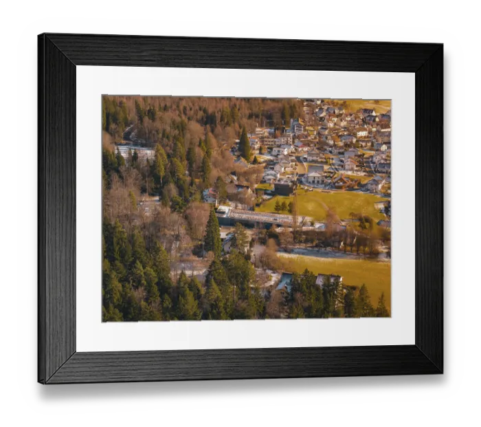 Framed Print : A bridge over a river surrounded by trees leads to a village in a snowy landscape Framed Print : A bridge over a river surrounded by trees leads to a village in a snowy landscape
