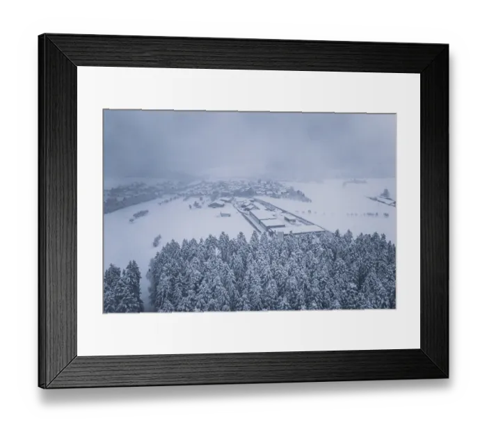 Framed Print : Aerial view of a snowy village surrounded by forests