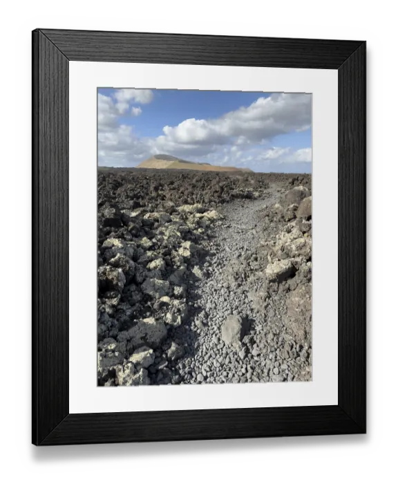 Framed Print : Hiking trail through lava rock to Caldera Blanca volcano against blue sky with white clouds