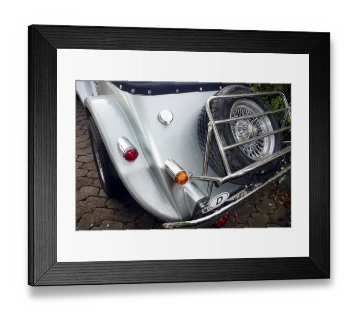 Framed Print : Back view of a vintage car with spare tires and chromed elements on cobblestones