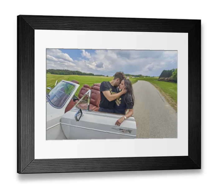 Framed Print : Couple sharing an affectionate moment by a white convertible on a rural road Framed Print : Couple sharing an affectionate moment by a white convertible on a rural road