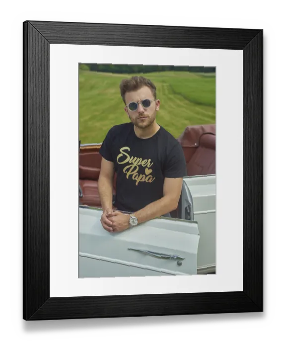 Framed Print : Man in sunglasses and watch leaning on a convertible in a lush green field Framed Print : Man in sunglasses and watch leaning on a convertible in a lush green field