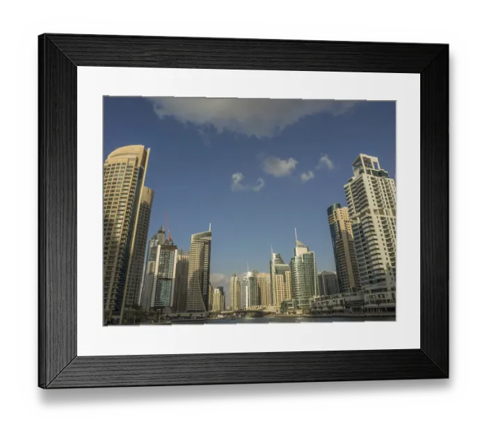 Framed Print : Skyscrapers of a modern city rise into the blue sky with few clouds