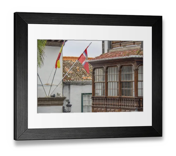 Framed Print : Detail of a colonial building with wooden balcony and waving flags