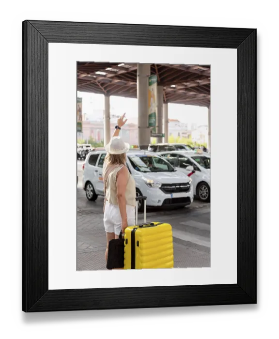 Framed Print : Woman with a yellow suitcase standing at a busy transportation hub