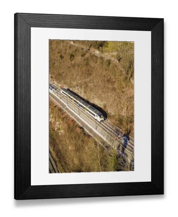 Framed Print : Aerial view of a train traveling through a wooded area surrounded by bare trees