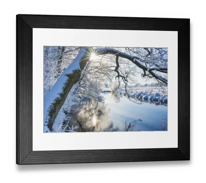 Framed Print : Snow-covered river landscape with trees