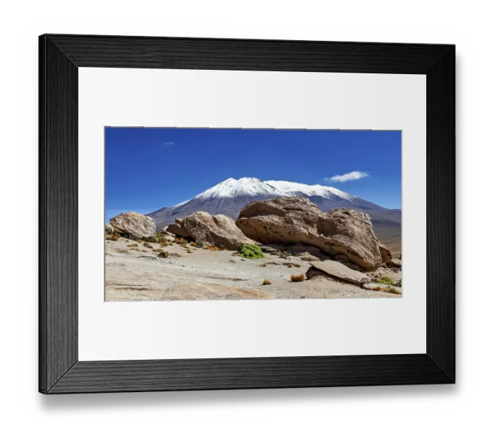 Framed Print : Rocks in desert area with a snow-covered mountain in the background under bright blue sky Framed Print : Rocks in desert area with a snow-covered mountain in the background under bright blue sky