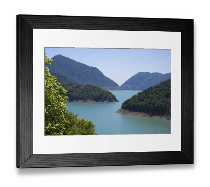 Framed Print : Large, calm lake surrounded by forested mountains