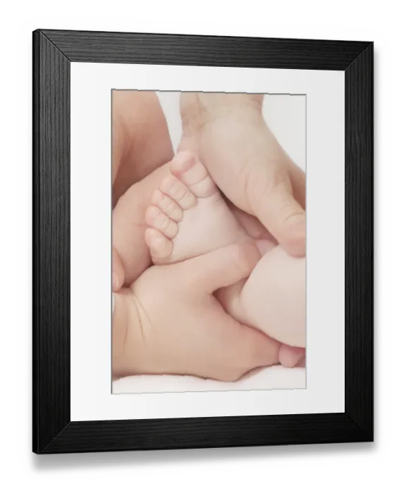Framed Print : Hands of a teenager and woman hold the baby foot Framed Print : Hands of a teenager and woman hold the baby foot