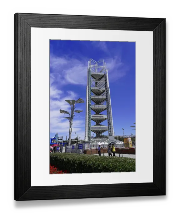 Framed Print : Modern tower under blue sky with light clouds and urban environment