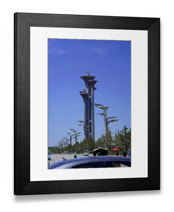 Framed Print : Tall Olympic tower in modern architecture surrounded by trees and clear sky