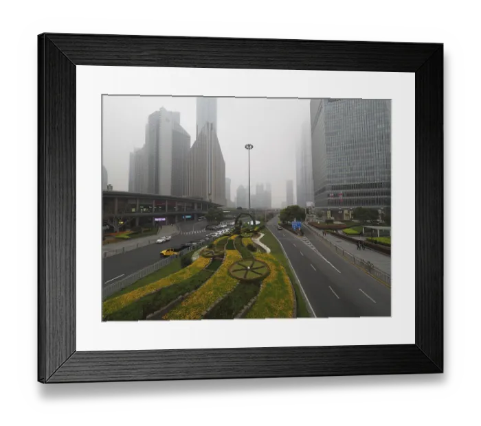 Framed Print : Flower bed along a road in a foggy urban area with high-rise buildings Framed Print : Flower bed along a road in a foggy urban area with high-rise buildings