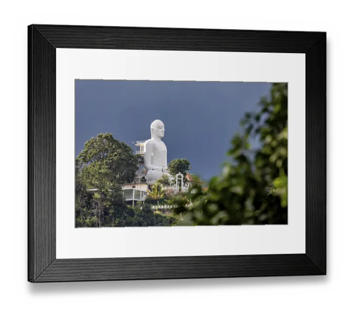 Framed Print : Large white Buddha statue on a hill surrounded by lush nature under blue sky