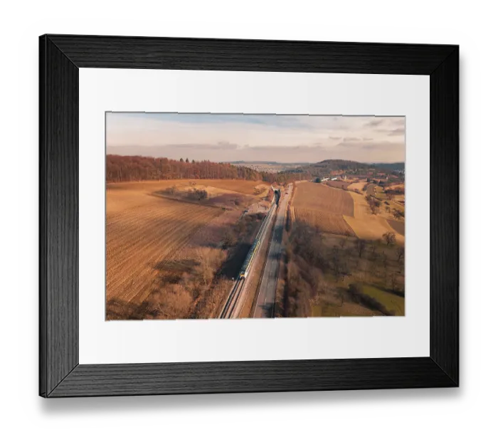 Framed Print : Wide landscape with railroad tracks and a distant train