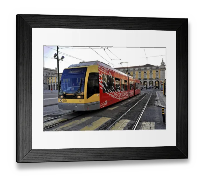 Framed Print : A modern red and yellow tram on rails in front of a historic building in a city center Framed Print : A modern red and yellow tram on rails in front of a historic building in a city center