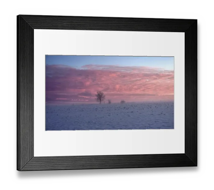 Framed Print : A snowy field under a pink sky at sunset