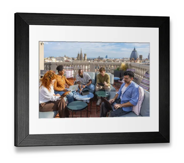 Framed Print : Diverse colleagues brainstorm and collaborate on laptops and tablets on a vibrant rooftop terrace in barcelona