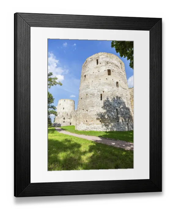Framed Print : Stone tower of the ancient Izborsk fortress against a blue sky in summer