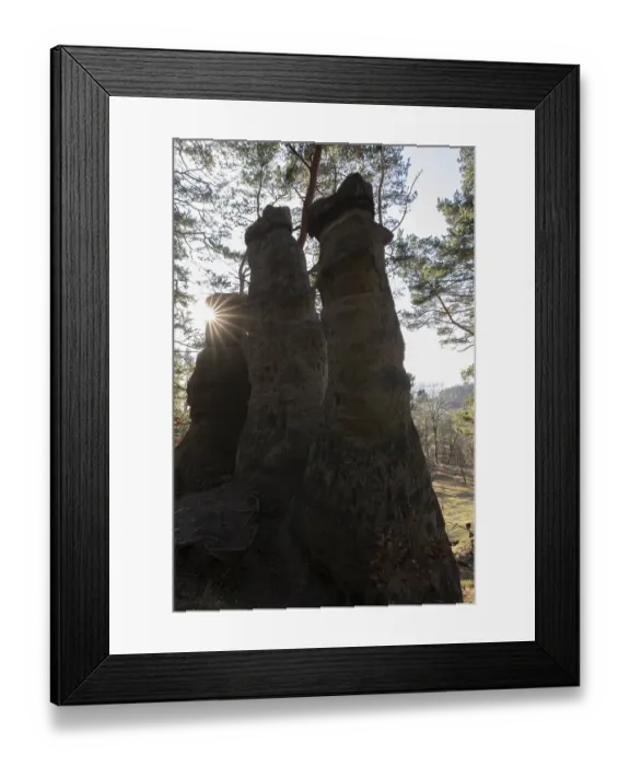 Framed Print : Sun rays appearing between two high rocks in the forest