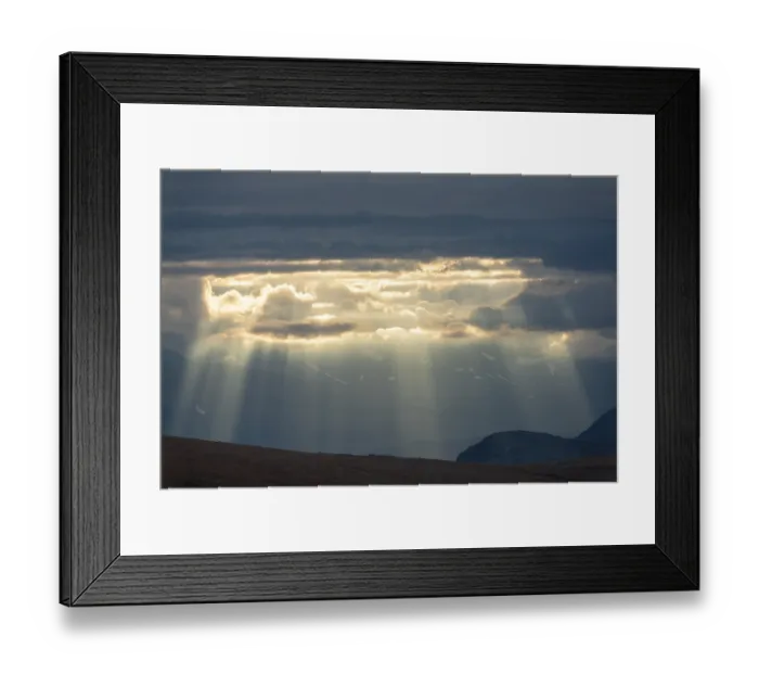 Framed Print : Sun rays fall through clouds in mountain landscape